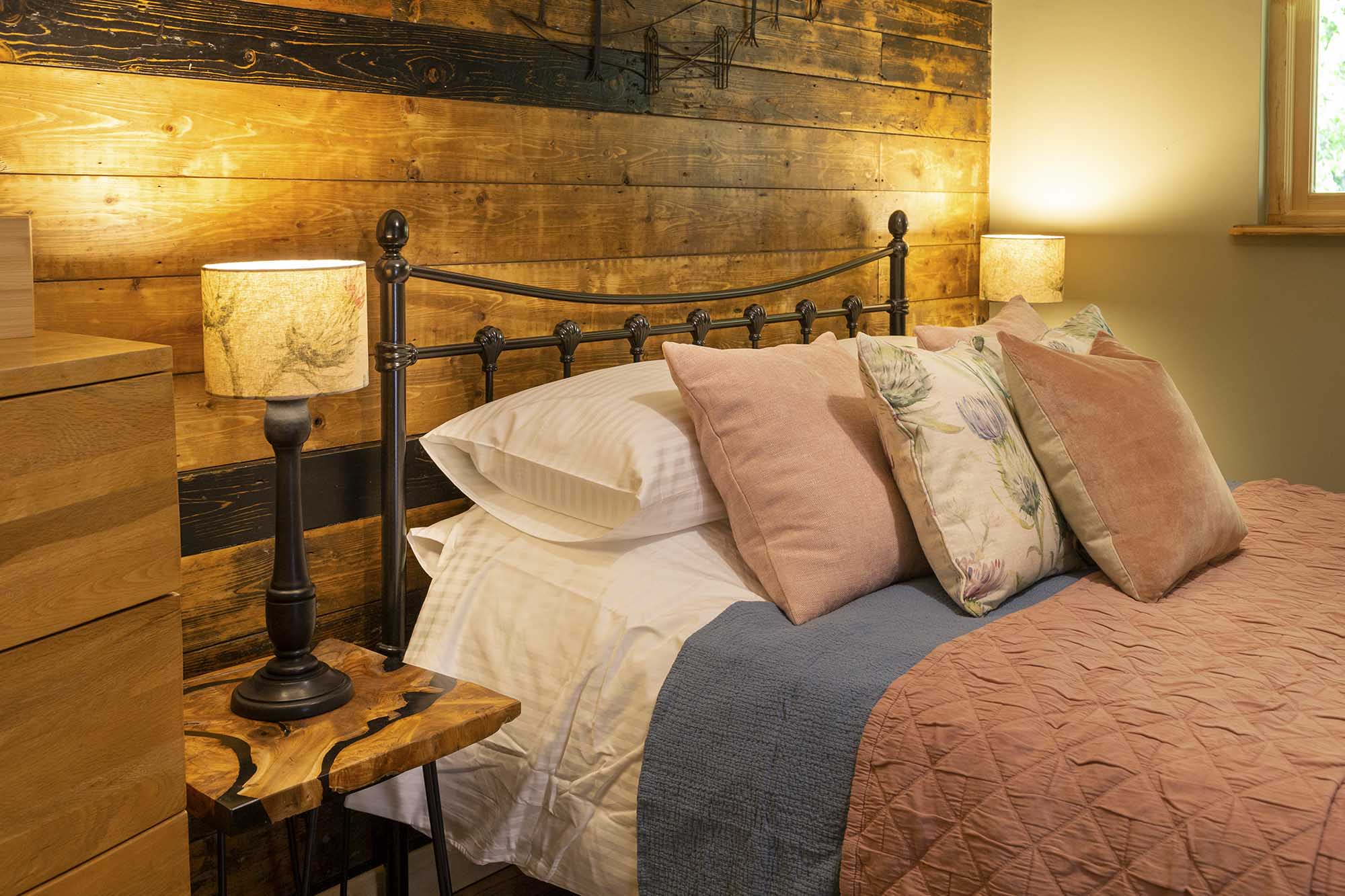 Professional glamping interior photography at Woodland Chase, showcasing handcrafted wooden walls and premium bedding