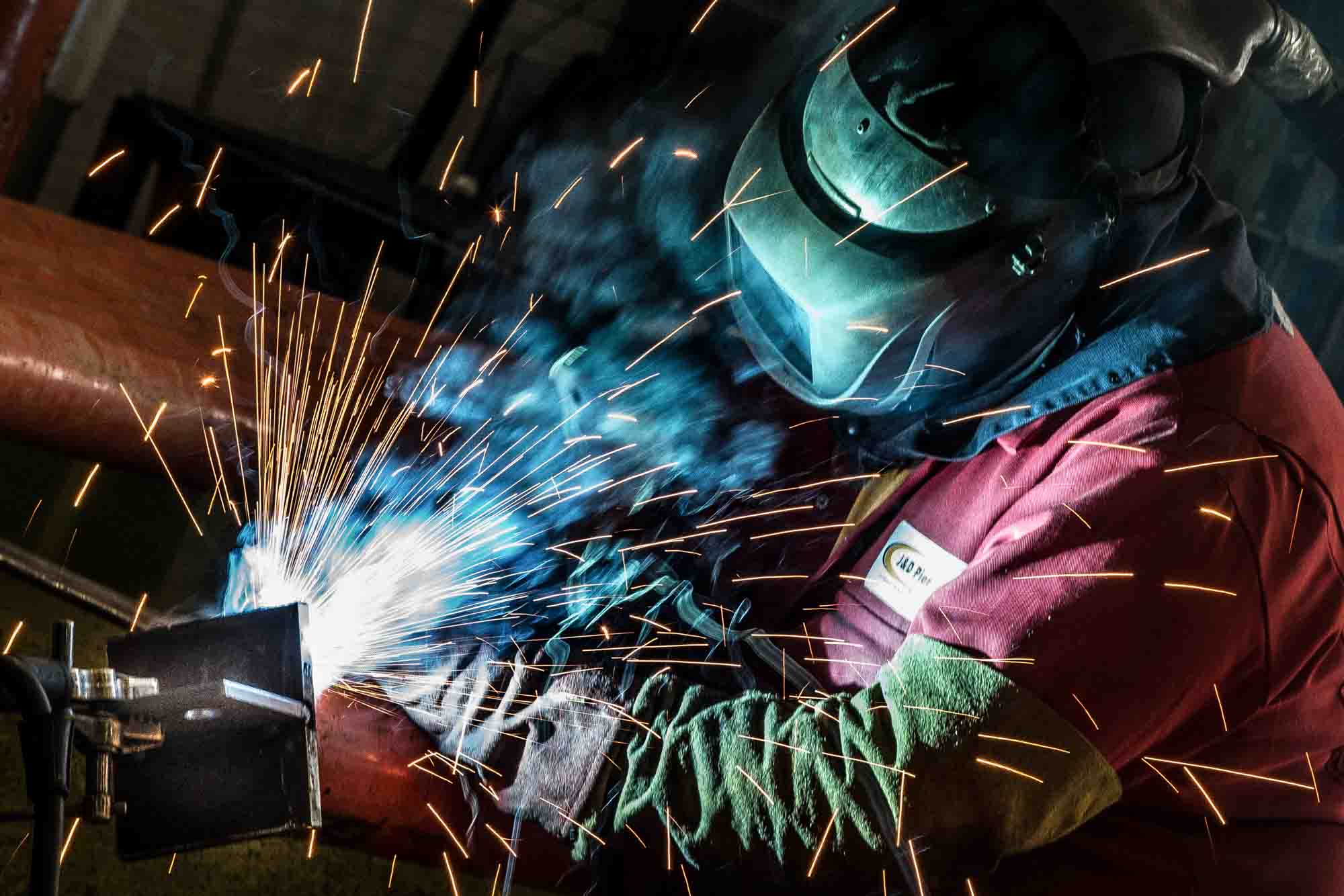 Dynamic brand photography of steel fabrication welding with sparks